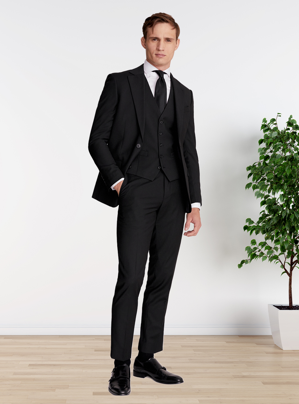 black three-piece suit, white shirt, and a black tie