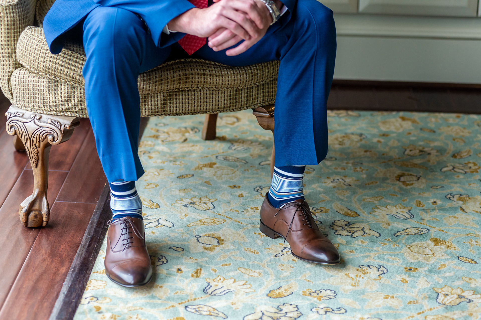 Blue suit, white blue patterned socks, and brown oxford shoes