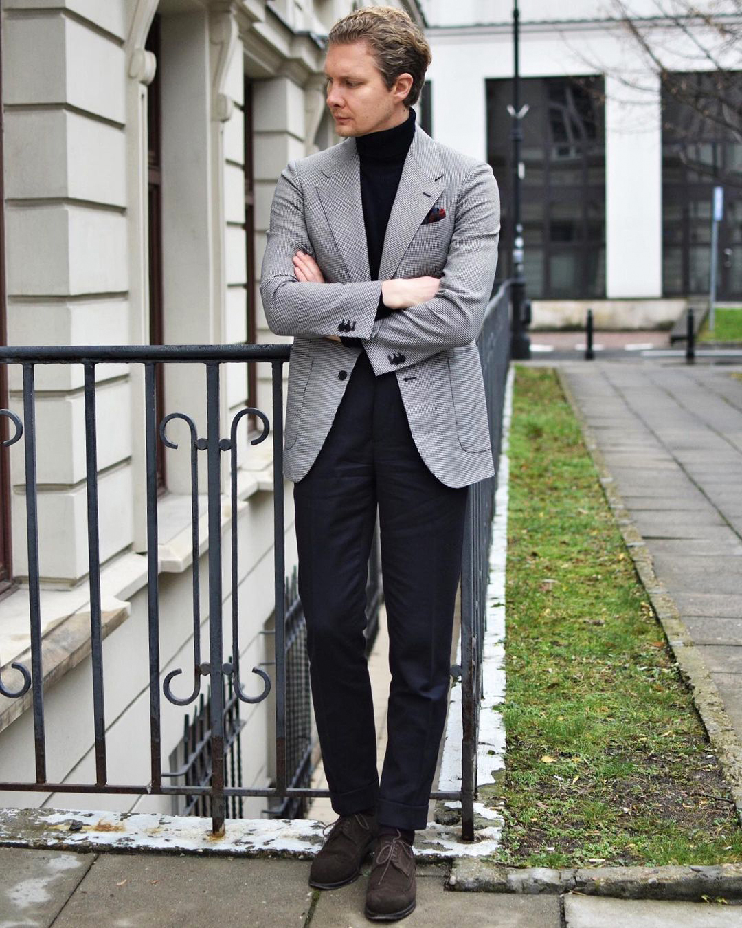 Grey blazer, black turtleneck, navy trousers, and brown derby shoes