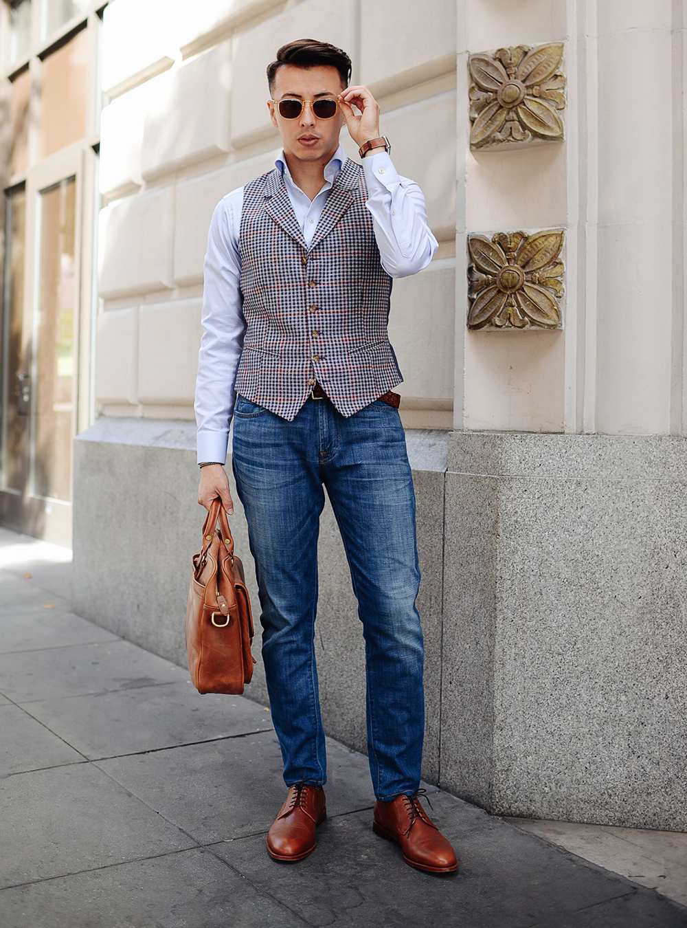 grey vest, white shirt, blue jeans, and brown Derby shoes