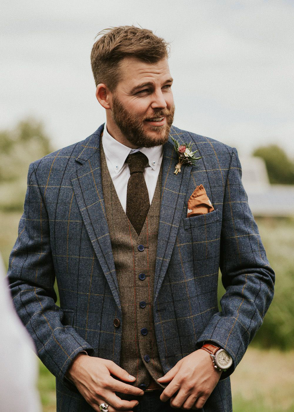 informal winter wedding outfit: grey plaid suit jacket and brown tweed vest with brown knit tie