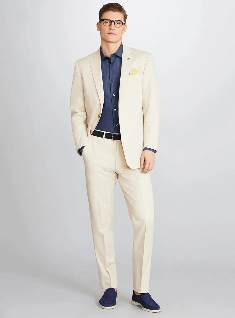 tan suit, denim shirt, and navy blue loafers